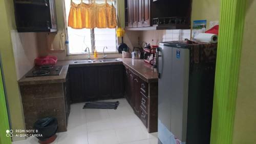 een kleine keuken met een wastafel en een koelkast bij Aqil Homestay Lunas Kulim for Mslim only in Lunas
