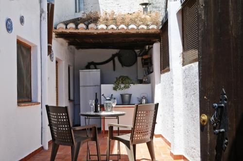 a small kitchen with a table and chairs in a room at Las Huertas in Monachil