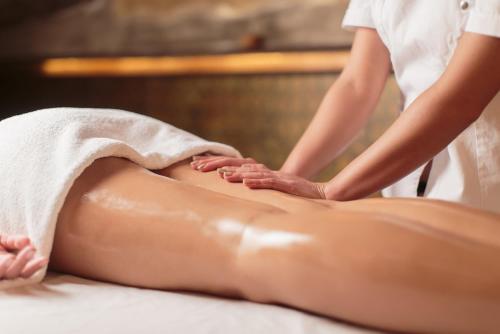 una mujer recibiendo un masaje de espalda en un spa en Masseria Le Terrazze di Serranova, en Serranova