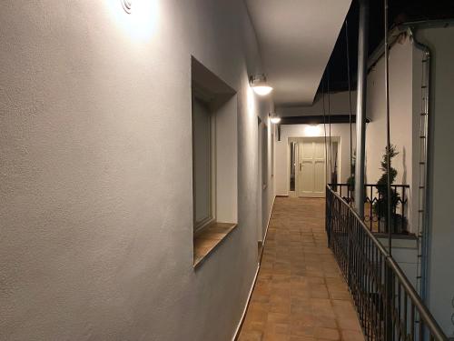 a hallway with a white wall and a mirror on the wall at Penzion U Anděla in Jičín