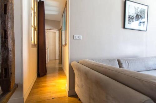 a living room with a couch and a hallway at Amazing 1 Bedroom Apartment at Abbesses in Paris