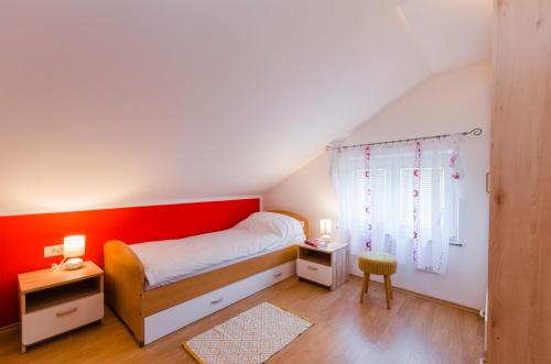 Un dormitorio con una cama y una pared roja. en Villa Valentina, en Bribir