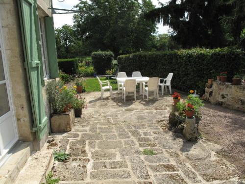 a patio with a table and chairs in a yard at Gîte de Pierre in Champlin