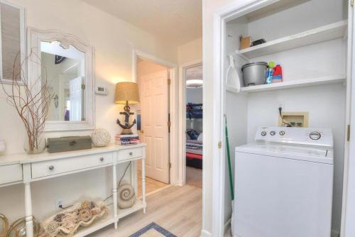 a kitchen with a sink and a washing machine at Just Peachy in Oak Island