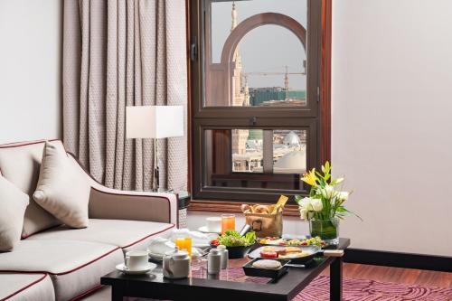 a living room with a couch and a table with food on it at Taiba Front Hotel in Al Madinah