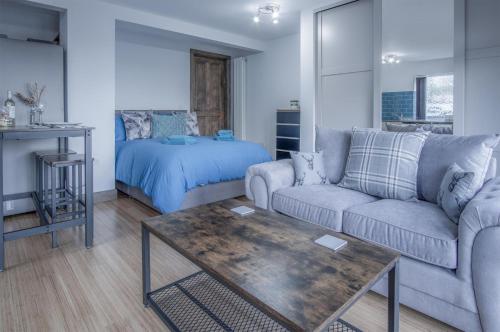 a living room with a couch and a bed at Haylands Hideaway - 1 Bedroom Apartment - Jameston in Manorbier