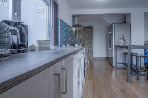 a kitchen with white cabinets and a counter top at Haylands Hideaway - 1 Bedroom Apartment - Jameston in Manorbier