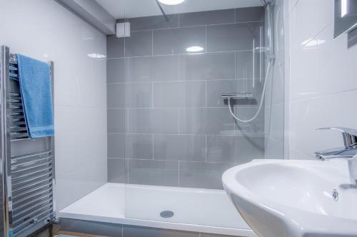 a white bathroom with a shower and a sink at Haylands Hideaway - 1 Bedroom Apartment - Jameston in Manorbier