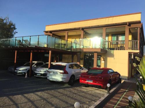 a group of cars parked in front of a building at Pousada Anjos - à 2 quadras do mar in Matinhos