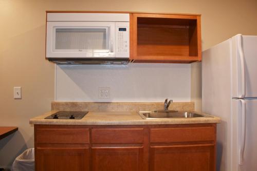 una cucina con lavello e microonde di WoodSpring Suites Williston a Williston