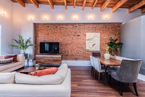 a living room with a brick wall and a table at Family Friendly 3-bedroom beauty in Le Plateau by DenStays in Montréal