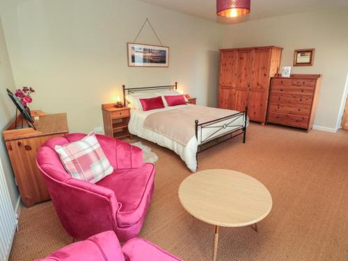 a bedroom with a bed and a couch and a table at The Bield in Eyemouth