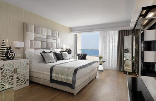 a bedroom with a large bed and a large window at Divani Apollon Palace & Thalasso in Athens