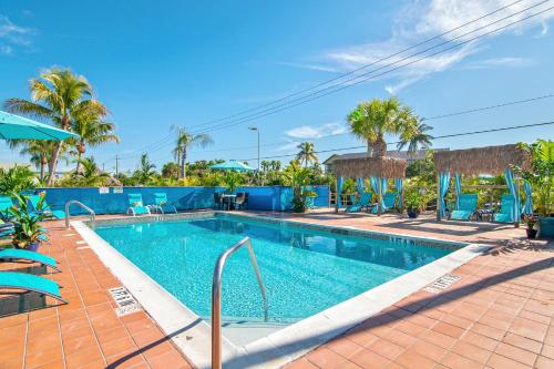 a swimming pool at a resort with palm trees at Latitude 26 Waterfront Resort and Marina in Fort Myers Beach