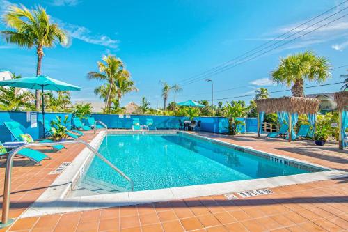 uma piscina num resort com palmeiras em Latitude 26 Waterfront Resort and Marina em Fort Myers Beach