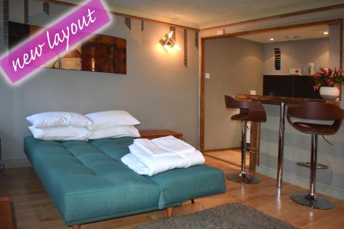 a green couch with white pillows on it in a salon at The Retreat Tranquil Countryside Apartment in Larkhall