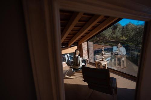 a woman sitting on a porch looking out a window at Borghetto San Biagio Relais Agriturismo in Thiene