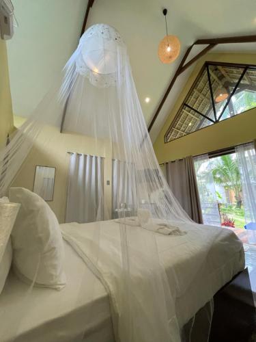 a bedroom with a bed with a mosquito net at EPBliss Siargao in General Luna