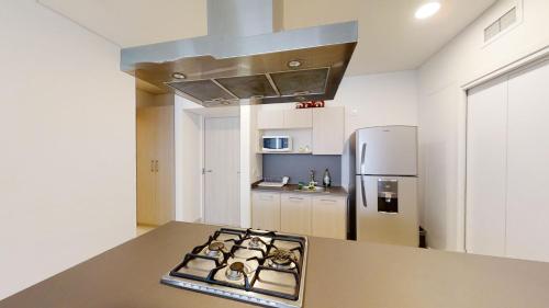 a kitchen with a stove and a refrigerator at Beautiful Apartment at Carso Residential with Pool in Mexico City