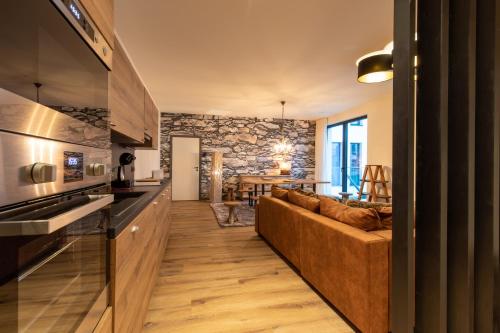 a kitchen and living room with a couch and a table at GUILLEMINS STATION FLATS in Liège