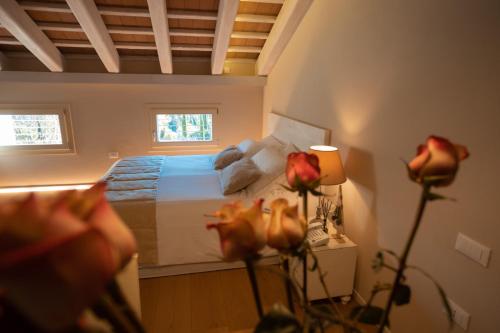 a bedroom with a bed and flowers in the foreground at Borghetto San Biagio Relais Agriturismo in Thiene