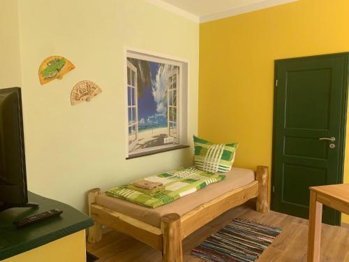 Pokój z łóżkiem z zielonymi drzwiami i telewizorem w obiekcie Pension Cubana w Rothenburgu