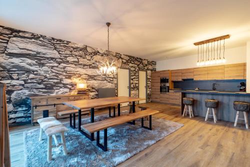 a dining room with a table and a stone wall at GUILLEMINS STATION FLATS in Liège