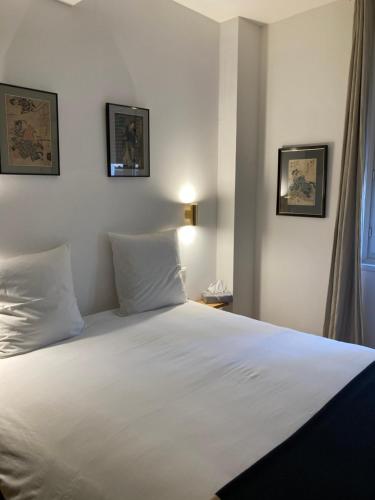 une chambre avec un grand lit blanc avec deux oreillers dans l'établissement KAROUBA.31, à Avignon