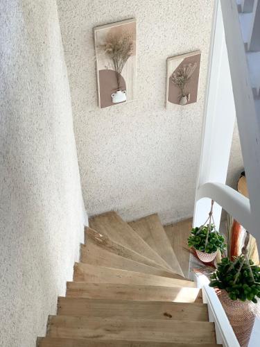 a staircase with wooden floors and pictures on the wall at Le Gîte des Rochettes, 600m à pied du Zoo de Beauval in Saint-Aignan