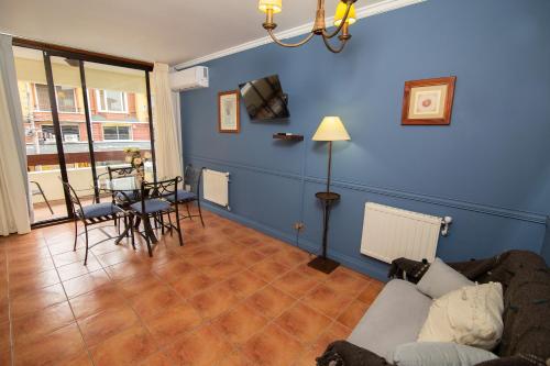 a blue living room with a couch and a table at Hotel del Volcán in Pucón