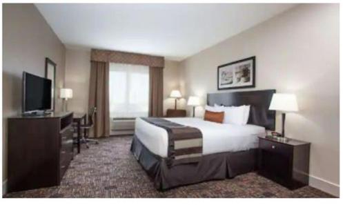 a hotel room with a bed and a flat screen tv at Radisson Hotel Edmonton Airport in Leduc