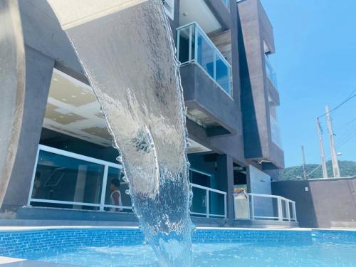 einem Brunnen vor einem Gebäude in der Unterkunft Apto novo com piscina em Ubatuba - Praia Maranduba in Ubatuba