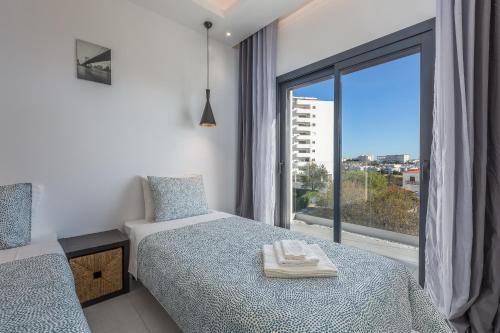 a bedroom with a bed and a large window at Correeira Luxury Residence in Albufeira