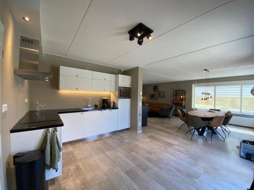 a kitchen and living room with a table and a dining room at Vakantievilla Overberg in Overberg