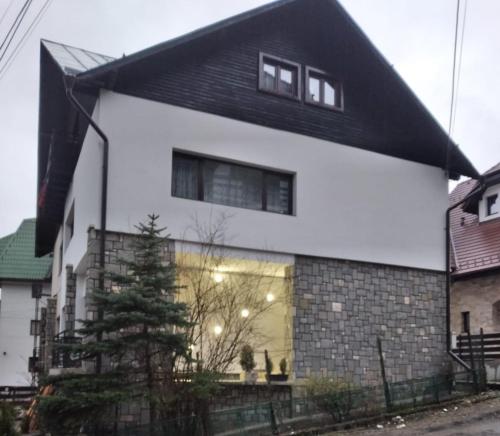 a white house with a black roof at Residence SINAIA Apartments in Sinaia