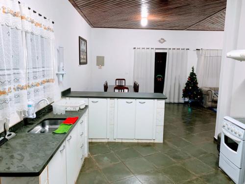 a kitchen with a christmas tree in the background at Recanto dos Cafezais in Bueno Brandão