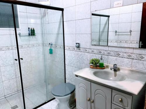 a bathroom with a sink and a shower and a toilet at Recanto dos Cafezais in Bueno Brandão