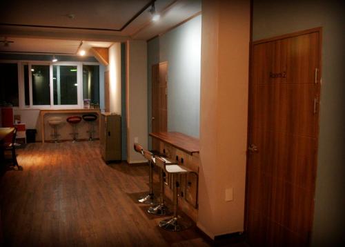 a room with a hallway with a table and chairs at Gangneung Guesthouse Myu in Gangneung