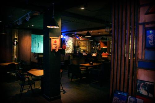 a restaurant with tables and chairs in a dark room at Gangneung Guesthouse Myu in Gangneung
