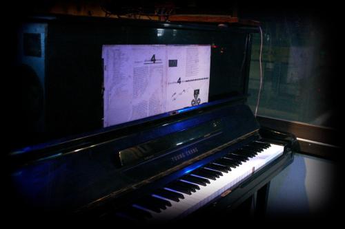 an old piano sitting in a dark room at Gangneung Guesthouse Myu in Gangneung