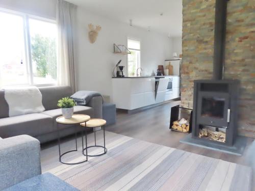 a living room with a couch and a fireplace at Vakantiehuis GWEN - vlakbij meer- van S&G Holiday in Nykroppa