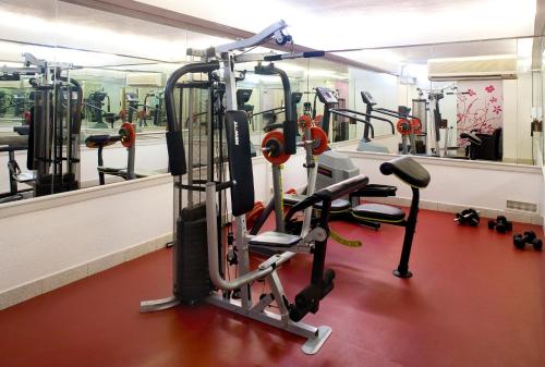 a gym with several tread machines and a mirror at Algarve Casino Hotel in Portimão