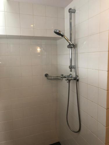 アムステルダムにあるKG Houseの白いタイル張りのバスルーム(シャワー、ホース付)