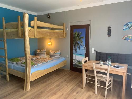 a bedroom with a bunk bed and a table at Pension Cubana in Rothenburg