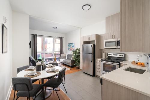 Una cocina y una sala de estar con mesa y sillas. en Hotel-Apart Prince Arthur, en Montreal