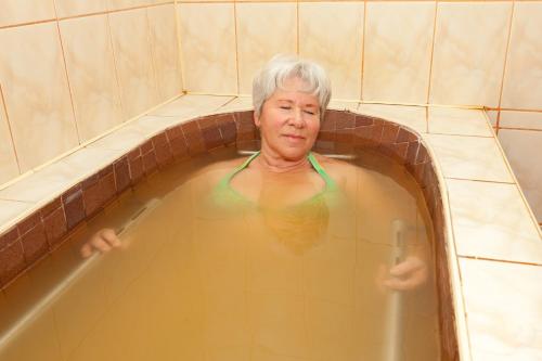 an older woman in a bath tub at Hotel Tusnad in Băile Tuşnad