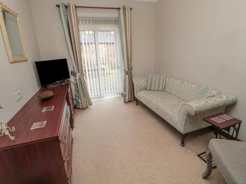 a living room with a couch and a tv at Barnacre in Morpeth