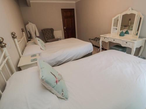 a bedroom with two beds and a desk and a mirror at Barnacre in Morpeth