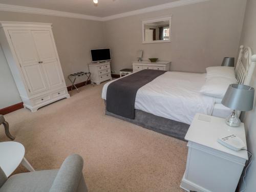 a bedroom with a bed and a desk and a tv at Barnacre in Morpeth