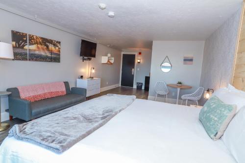 a bedroom with a large white bed and a couch at Gunstock Inn & Suites in Gilford